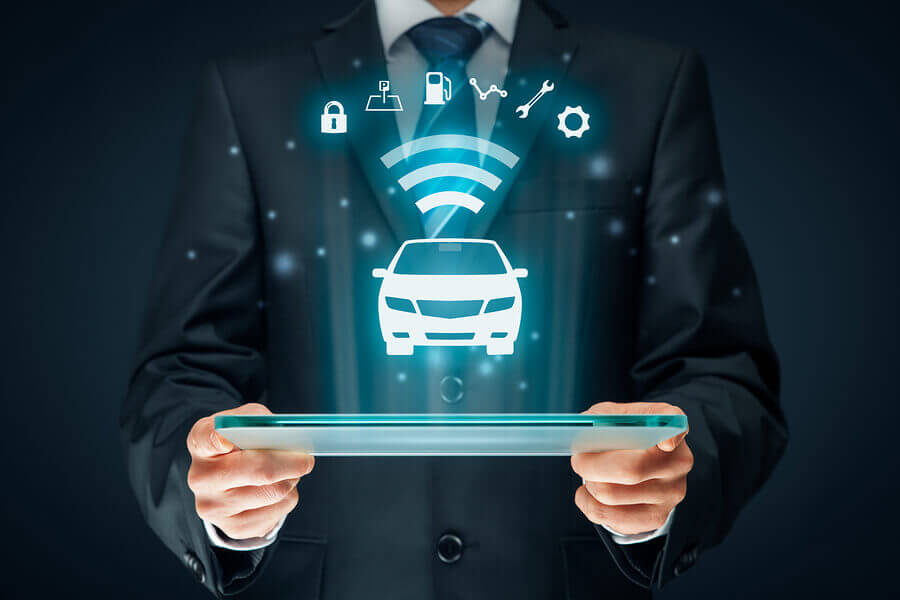 A businessman holding a tablet showing a car icon